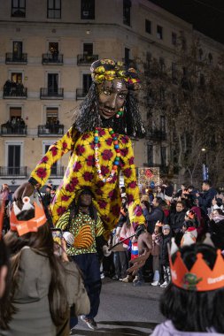 Akşam Barselona sokaklarında üç kralın geçit töreni. Barcelona İspanya Geçit Töreni 'nde Parlak Karnaval kostümlü oyuncular 05.01.2026