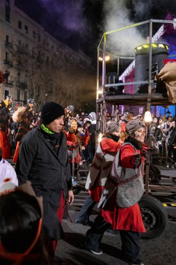 Akşam Barselona sokaklarında üç kralın geçit töreni. Barcelona İspanya Geçit Töreni 'nde Parlak Karnaval kostümlü oyuncular 05.01.2026