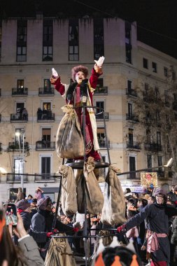 Akşam Barselona sokaklarında üç kralın geçit töreni. Barcelona İspanya Geçit Töreni 'nde Parlak Karnaval kostümlü oyuncular 05.01.2026