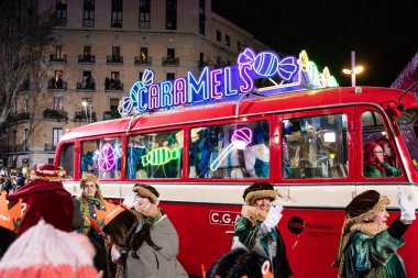 Akşam Barselona sokaklarında üç kralın geçit töreni. Barcelona İspanya Geçit Töreni 'nde Parlak Karnaval kostümlü oyuncular 05.01.2026