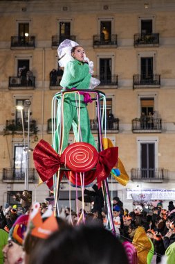 Akşam Barselona sokaklarında üç kralın geçit töreni. Barcelona İspanya Geçit Töreni 'nde Parlak Karnaval kostümlü oyuncular 05.01.2026