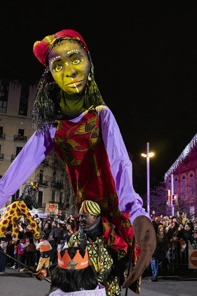 Akşam Barselona sokaklarında üç kralın geçit töreni. Barcelona İspanya Geçit Töreni 'nde Parlak Karnaval kostümlü oyuncular 05.01.2026