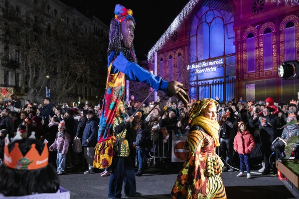 Akşam Barselona sokaklarında üç kralın geçit töreni. Barcelona İspanya Geçit Töreni 'nde Parlak Karnaval kostümlü oyuncular 05.01.2026