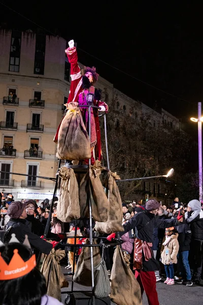 Akşam Barselona sokaklarında üç kralın geçit töreni. Barcelona İspanya Geçit Töreni 'nde Parlak Karnaval kostümlü oyuncular 05.01.2026