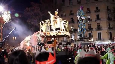 Akşam Barselona sokaklarında üç kralın geçit töreni. Barcelona İspanya Geçit Töreni 'nde Parlak Karnaval kostümlü oyuncular 05.01.2026