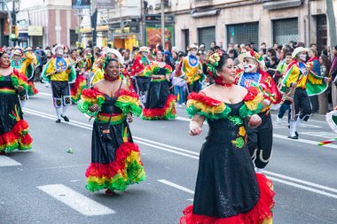 Barselona 'daki festival sokak karnavalında dünyanın farklı ülkelerinden parlak geleneksel kostümlü dansçılar yer alıyor. Barselona İspanya 14.02.2026