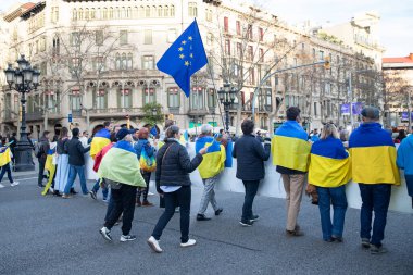 Ukraynalıların Avrupa 'daki barışçıl mitingleri uzun savaş yıllarını ve Rus saldırganlığını hatırlatıyor. Ukrayna 'da barışı destekleyen bayraklı ve posterli eylemciler. Barselona İspanya 22.02.2026