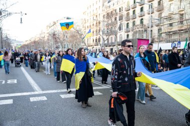 Ukraynalıların Avrupa 'daki barışçıl mitingleri uzun savaş yıllarını ve Rus saldırganlığını hatırlatıyor. Ukrayna 'da barışı destekleyen bayraklı ve posterli eylemciler. Barselona İspanya 22.02.2026