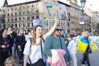Ukraynalıların Avrupa 'daki barışçıl mitingleri uzun savaş yıllarını ve Rus saldırganlığını hatırlatıyor. Ukrayna 'da barışı destekleyen bayraklı ve posterli eylemciler. Barselona İspanya 22.02.2026