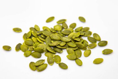 beyaz zemin üzerine soyulmuş kabak çekirdeği