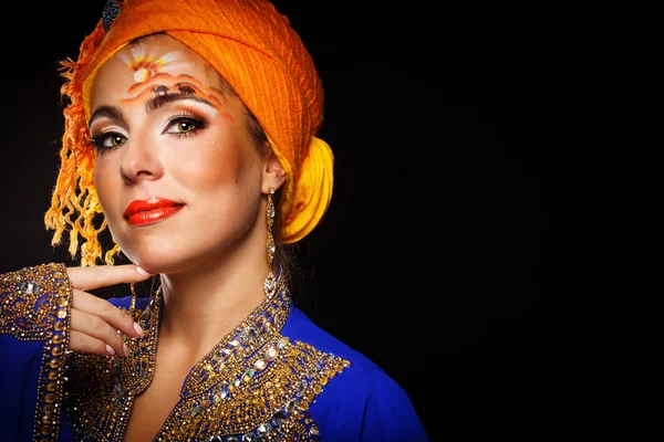 Portrait of oriental beauty in a turban and face art.