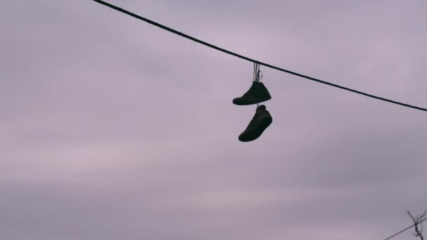 Shoes hanging by laces from a wire — Stock Video