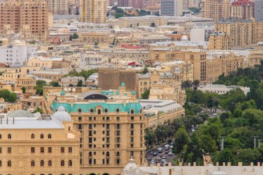 Bakü, Azerbaycan. Azerbaycan 'ın başkenti Bakü' nün panoramik manzarası. Görüntü klasik mimarinin, yoğun yeşil park alanlarının ve arka planda Hazar Denizi 'ne doğru eğimli modern şehir siluetinin bir karışımını yakalar. Sen... 