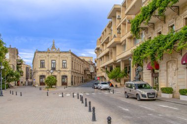 Bakü - Azerbaycan. Azerbaycan 'ın Bakü kentindeki Hasan bey Zardabi heykelinin üzerinde sanatsal ağaç tasarımı bulunan bir kitabı var. La Opera restoranının önünde..