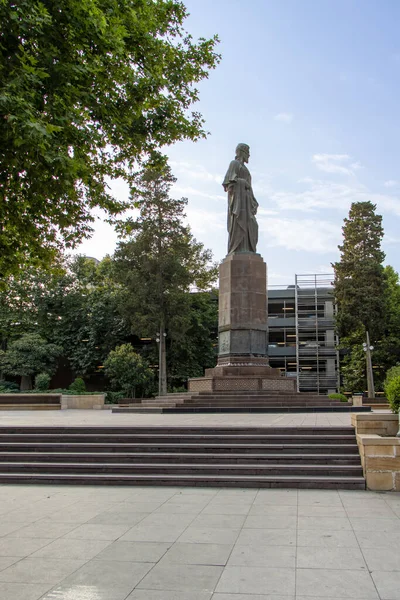 BAKU, AZERBAIJAN. Monument to the medieval classic of Persian poetry Nizami Ganjavi in the urban landscape.