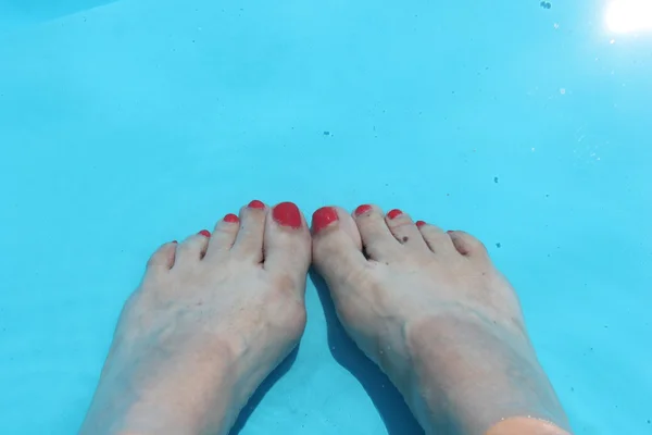 swimming pool poolside feet in background water ripple texture reflection with copy space,