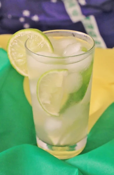 Fresh lime caipirinha on Brazilian flag — Stock Photo, Image