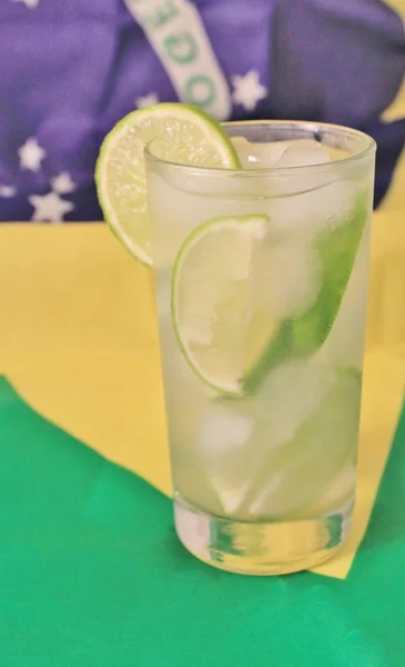 Fresh lime caipirinha on Brazilian flag — Stock Photo, Image