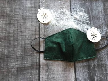 Covid 19 Coronavirus Noel konsepti. Yüz maskesi, Noel süslemeleri ve noel baba şapkası arka planında fotokopi alanı. 