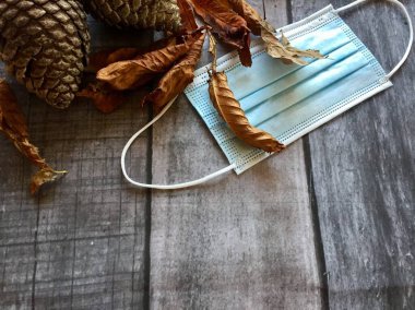 Sonbahar sonbaharı arka plan koronavirüs kavramlı, yüz maskeli ve kuru kış yapraklı covid 19 maske.