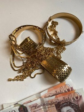 Altın yığını zincirler, bilezik mücevher dükkanı ve para.