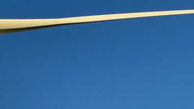 Elektrik enerjisi üreten rüzgar türbinleri. Rüzgâr değirmeni güç üretimi. Mavi gökyüzü ile yeşil alanda duran rüzgar türbinleri. Stok görüntüleri.
