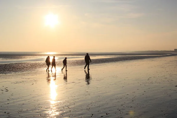 Persone Che Camminano Tramonto Riflettendo Sulla Sabbia Bagnata Beach Tra — Foto Stock