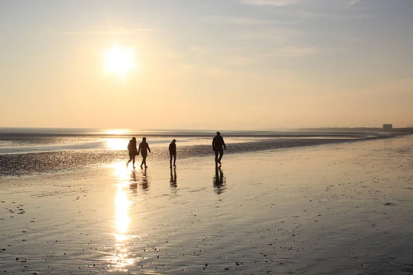 Persone Che Camminano Tramonto Riflettendo Sulla Sabbia Bagnata Beach Tra — Foto Stock