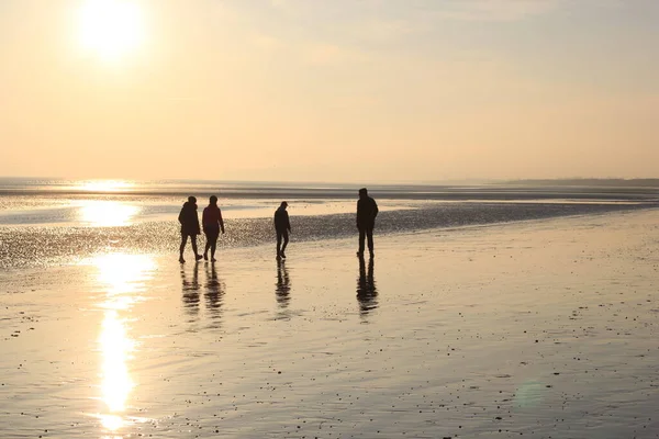 Persone Che Camminano Tramonto Riflettendo Sulla Sabbia Bagnata Beach Tra — Foto Stock