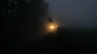 cars driving slowly in mist on a country lane