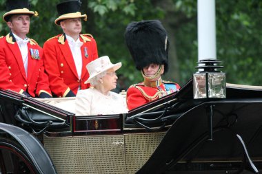 LONDON - JUNE 13: Queen Elizabeth II and Prince Philip seat on the Royal Coach at Queen's Birthday Parade, also known as Trooping the Colour, on June 13, 2015 in London, England. clipart