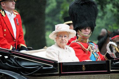 LONDON - JUNE 13: Queen Elizabeth II and Prince Philip seat on the Royal Coach at Queen's Birthday Parade, also known as Trooping the Colour, on June 13, 2015 in London, England. clipart
