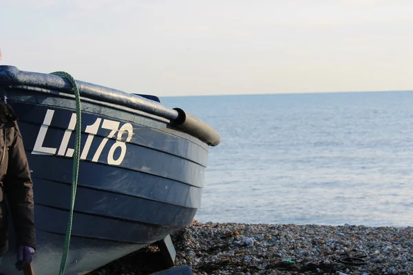 Barco de pesca de madeira em uma praia de calhau — Fotografia de Stock