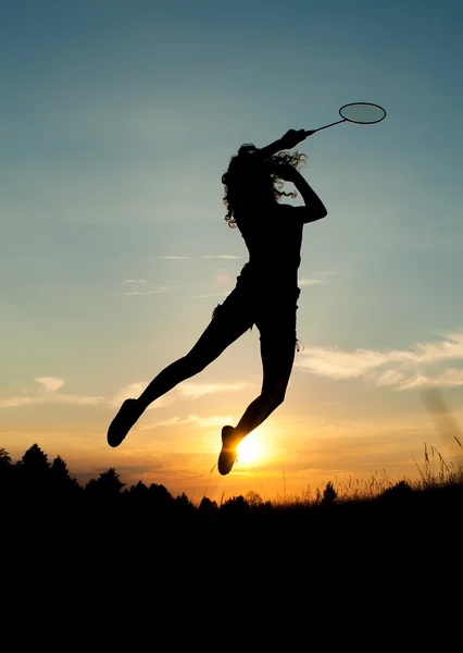 Springendes Mädchen spielt Badminton Stockbild