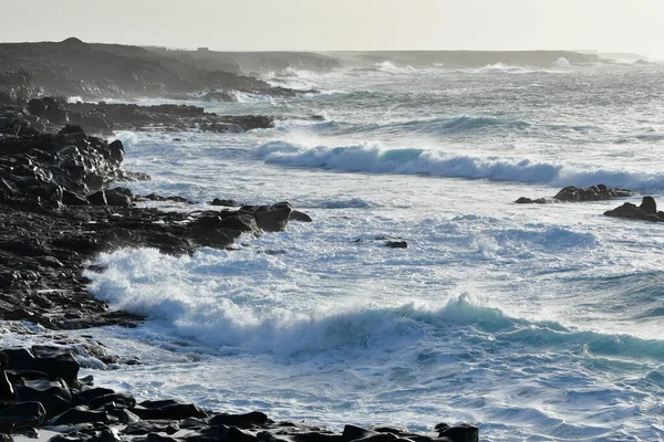 Akşam güneşinde Lanzarote 'nin batı kıyısında. Okyanus dalgaları lav taşlarını kırıyor. Kanarya Adaları, İspanya.