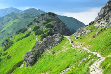 Polonya-Slovakya sınırı boyunca Kasprov Vrch Dağı 'ndan çıkıntı. Yolda bazı yürüyüşçüler var. Yüksek Tatra, Polonya.