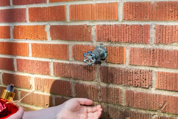 Vrouw Met Behulp Van Een Outdoor Spigot Naar Wassen Haar — Stockfoto