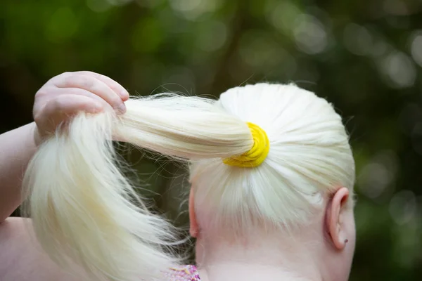 一个女人 留着长长的 白色的头发 留着一条黄色的马尾辫 — 图库照片