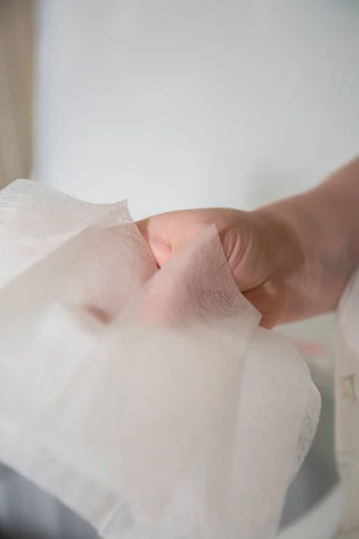 A woman\'s hand as she holds dryer sheets for laundry