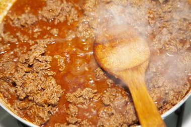 Tahta kaşıkla tavada kızartılmış angus bifteği.