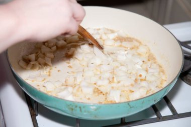 Kızartma tavasında doğranmış sarı soğan ve sarımsak.