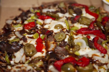 Bir karton içinde biftek ve biberli pizza taşıyın.