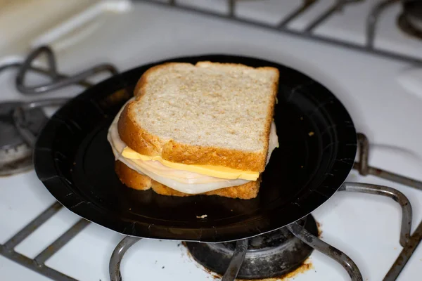 Sliced Chicken Cheese Sandwich Slathered Mustard Black Paper Plate Stove — Stock Photo, Image