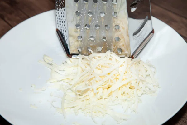 Haufen Geschredderter Weißer Käse Auf Einem Weißen Teller Neben Einer — Stockfoto