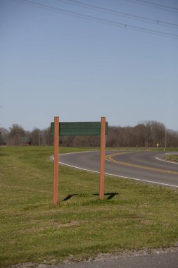 Dolambaçlı bir otoyolun yakınındaki çimlerin arkasında.