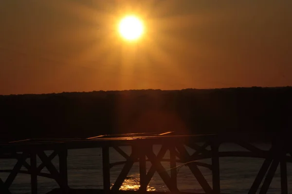 Gouden Zonsondergang Een Waterig Horzion Met Een Stalen Brugsilhouet Voorgrond — Stockfoto