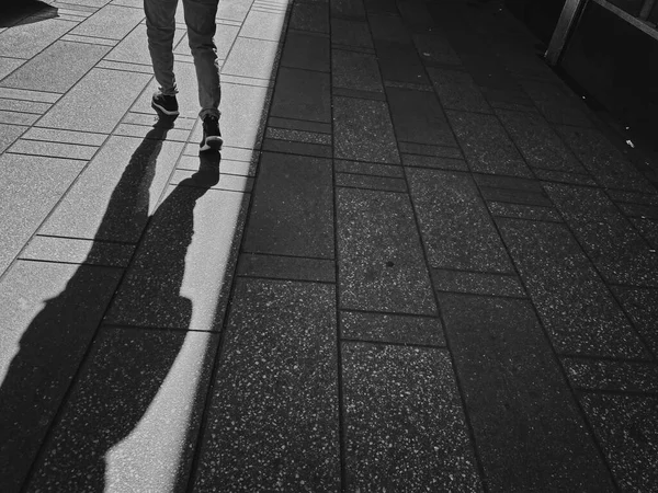 Mann Mit Hose Und Turnschuhen Zeigt Langen Schatten Auf Bürgersteig — Stockfoto