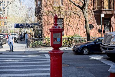 New York, New York, ABD - 11 Nisan 2021: 19. Cadde ve Irving Meydanı 'nın köşesinde üzerinde iki kağıt göz olan eski bir kırmızı alarm kutusu