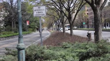 New York, New York, ABD - 20 Nisan 2021: Manhaatan 'daki Hudson Greenway' de Batı Caddesi 'ndeki araç trafiğinin yanında bisikletçiler