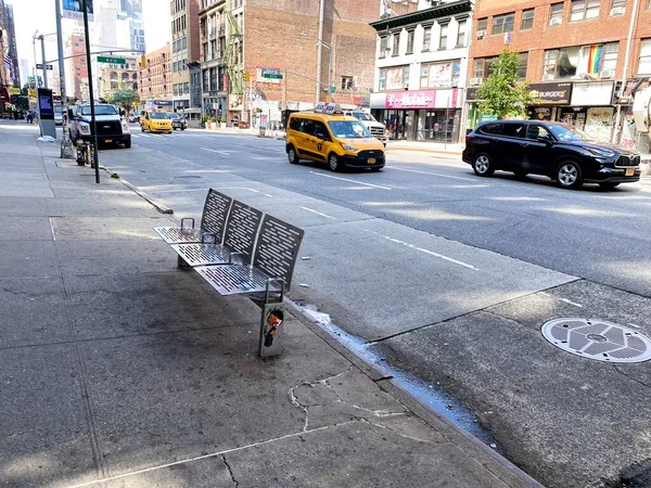 New York, New York, ABD - 6 Temmuz 2021: Altıncı Cadde 'deki kaldırımda demirli metal bir bank